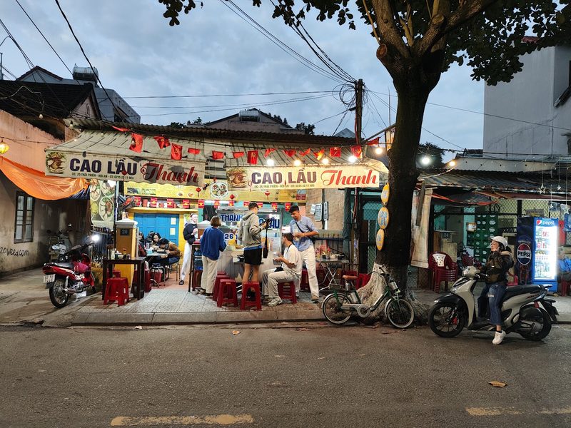 Mặt tiền Quán Cao Lầu Thanh lúc chiều tối với băng rôn đỏ «Cao Lầu Thanh»